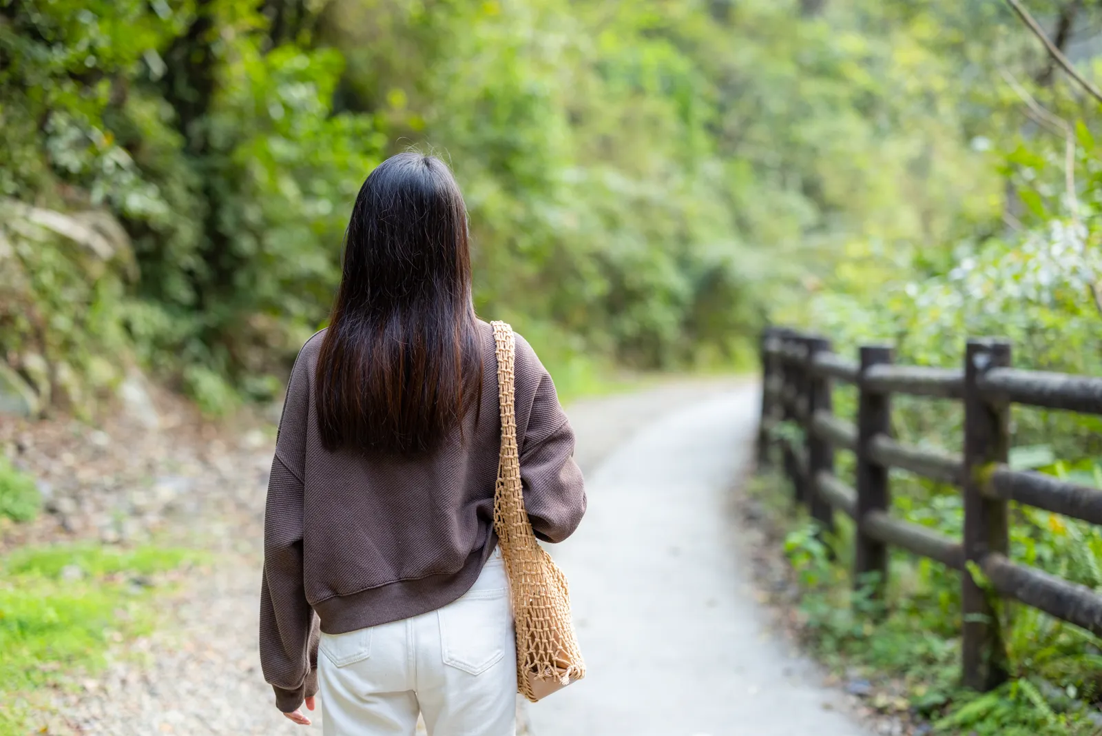 A woman walking on a forest path in autumn, casual jacket, no destination in mind