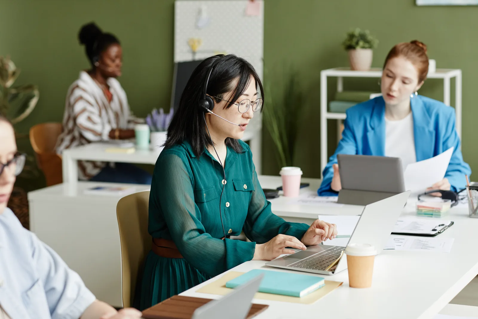 Two professionals collaborating in a modern bright office with laptops open between them