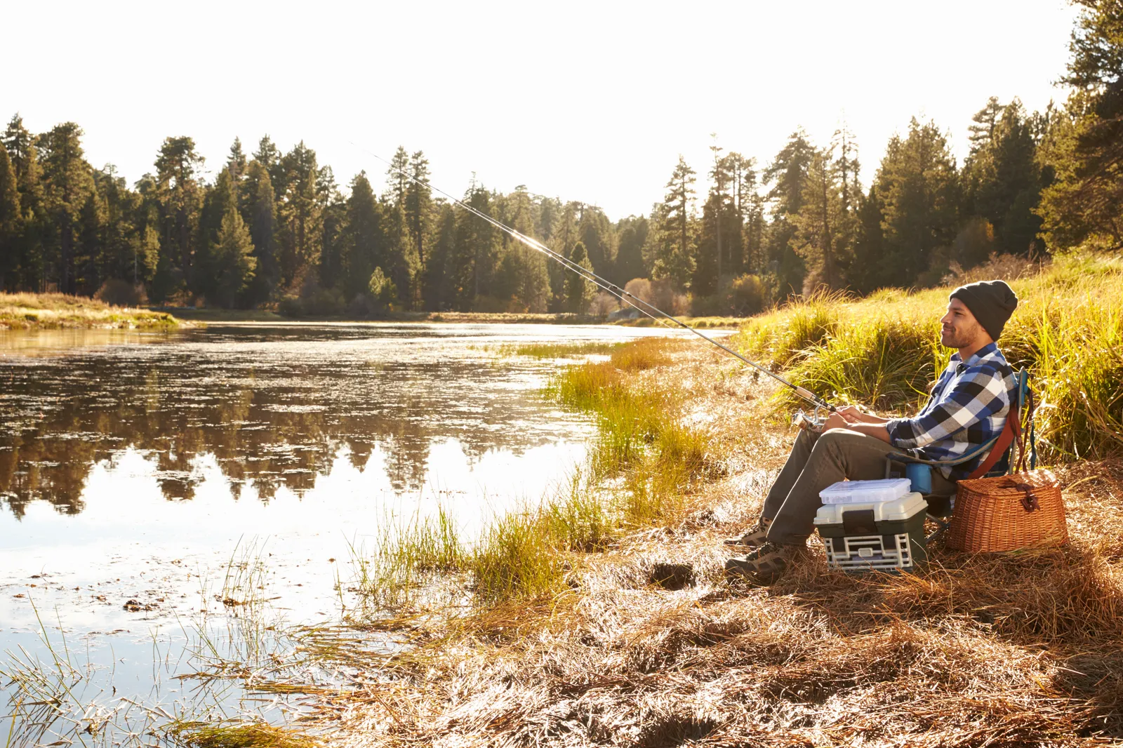 A man fishing from a small boat on a calm lake, peaceful morning