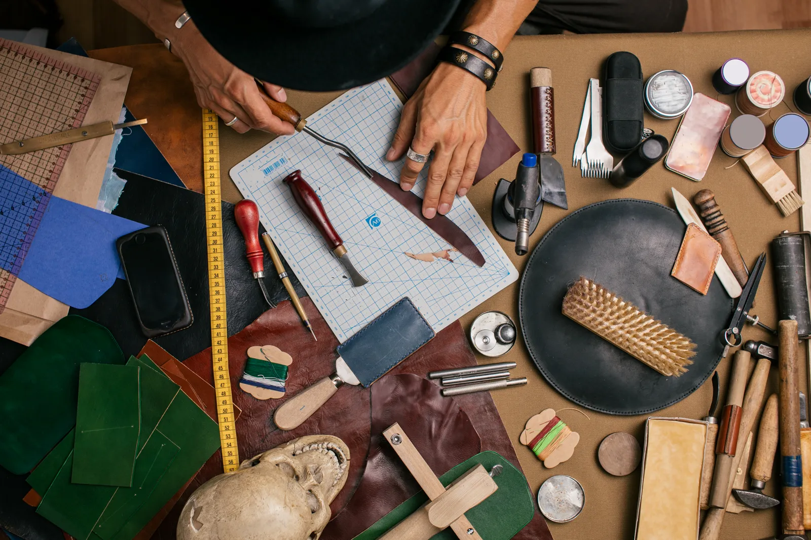 Close-up of a man's hands carving wood with a small knife, focused work