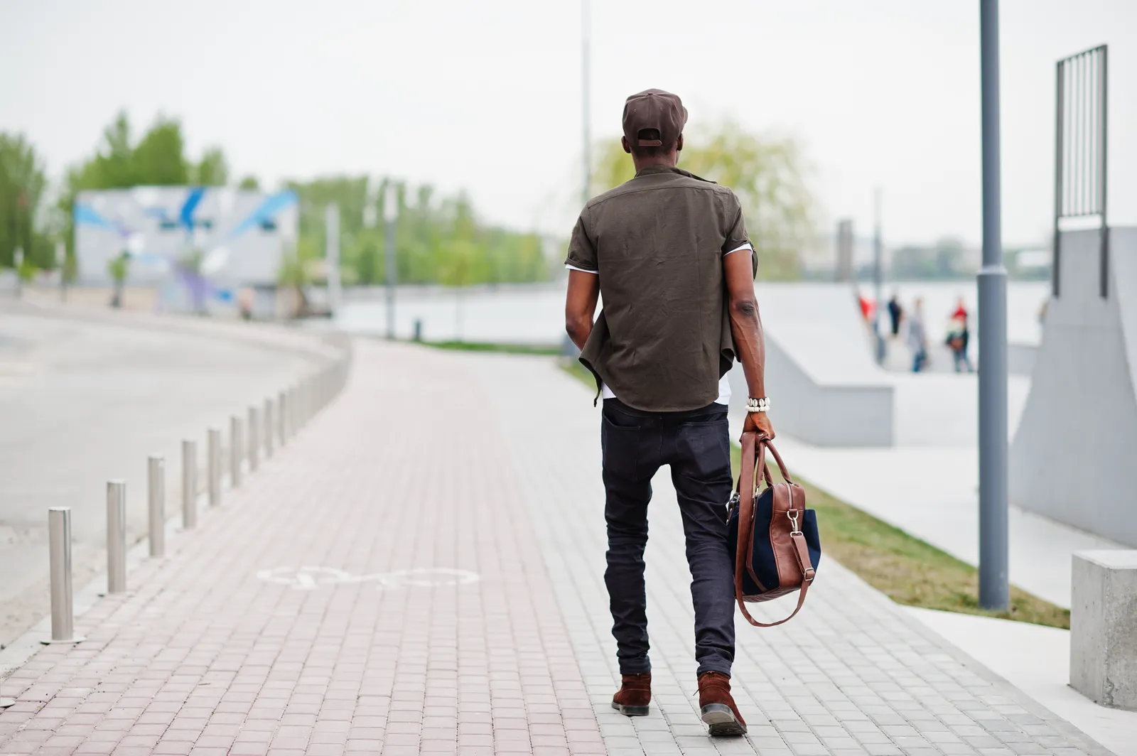 A man walking on a city sidewalk, casual clothes, no destination