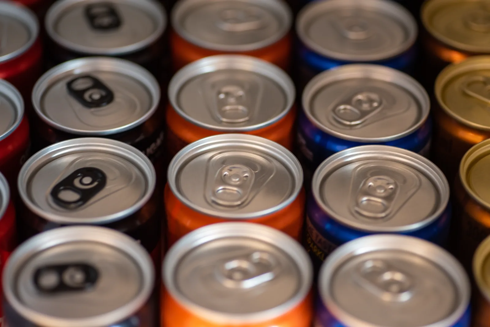 A close-up of a group of colorful soft drink cans clustered together