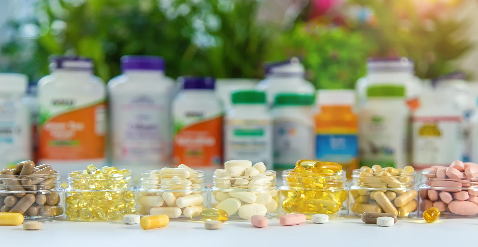 An assortment of supplement bottles, jars, and capsules arranged together, showing the variety of products in a typical aisle