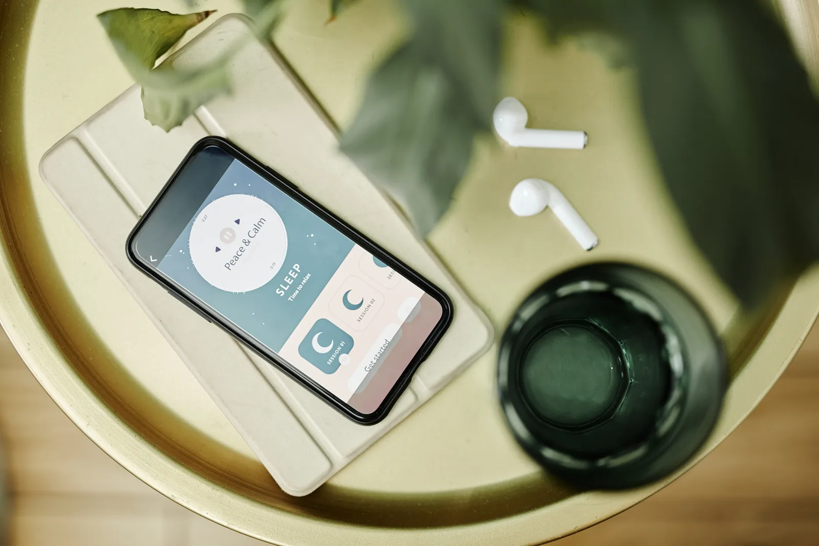 A relaxing evening routine with a smartphone showing a sleep meditation app, warm low lamplight