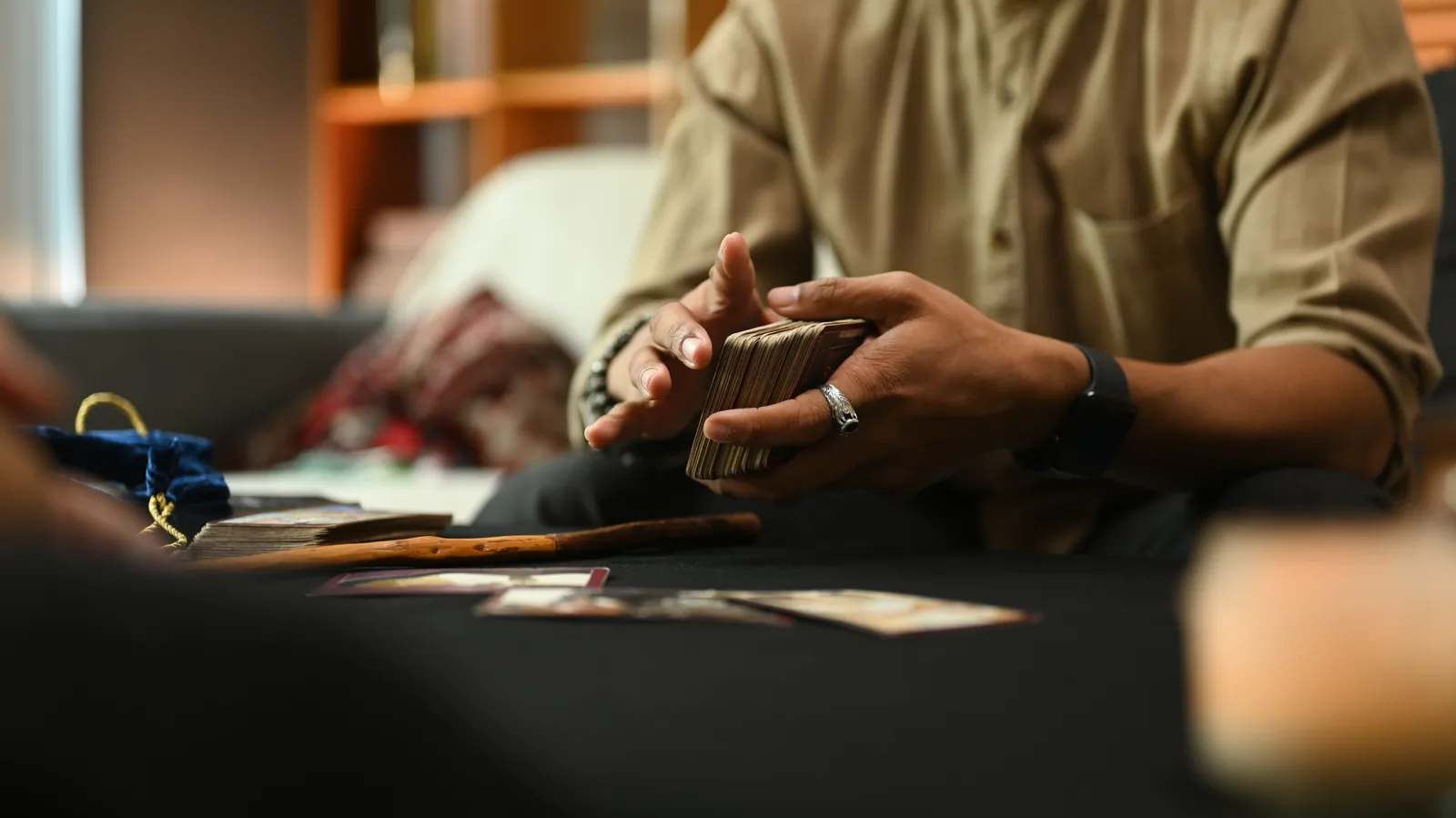 Close-up of hands holding a deck of cards on a table