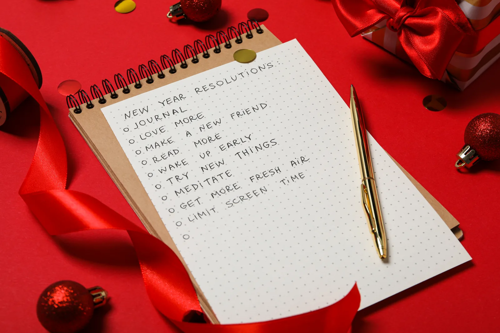 A handwritten list on paper with small decorations nearby, warm light