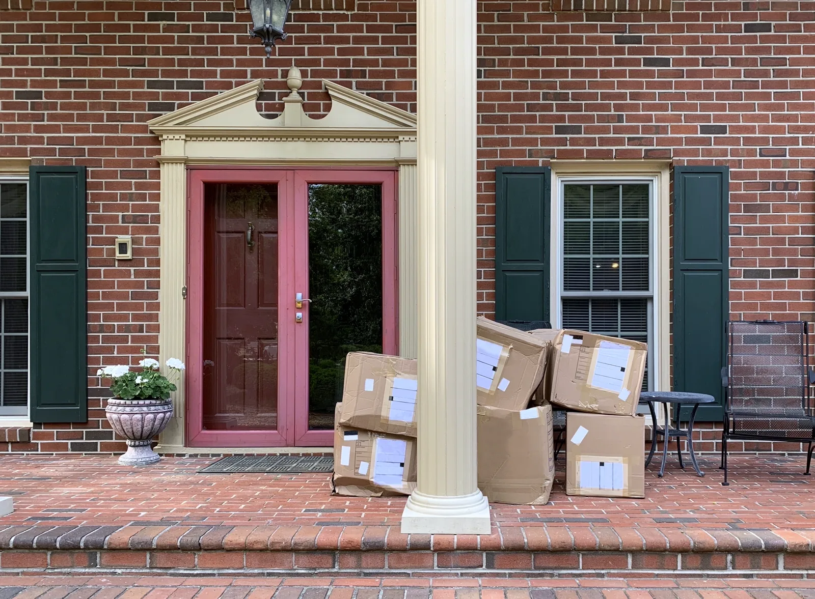 A pile of unopened Amazon packages stacked on a doorstep, soft afternoon light